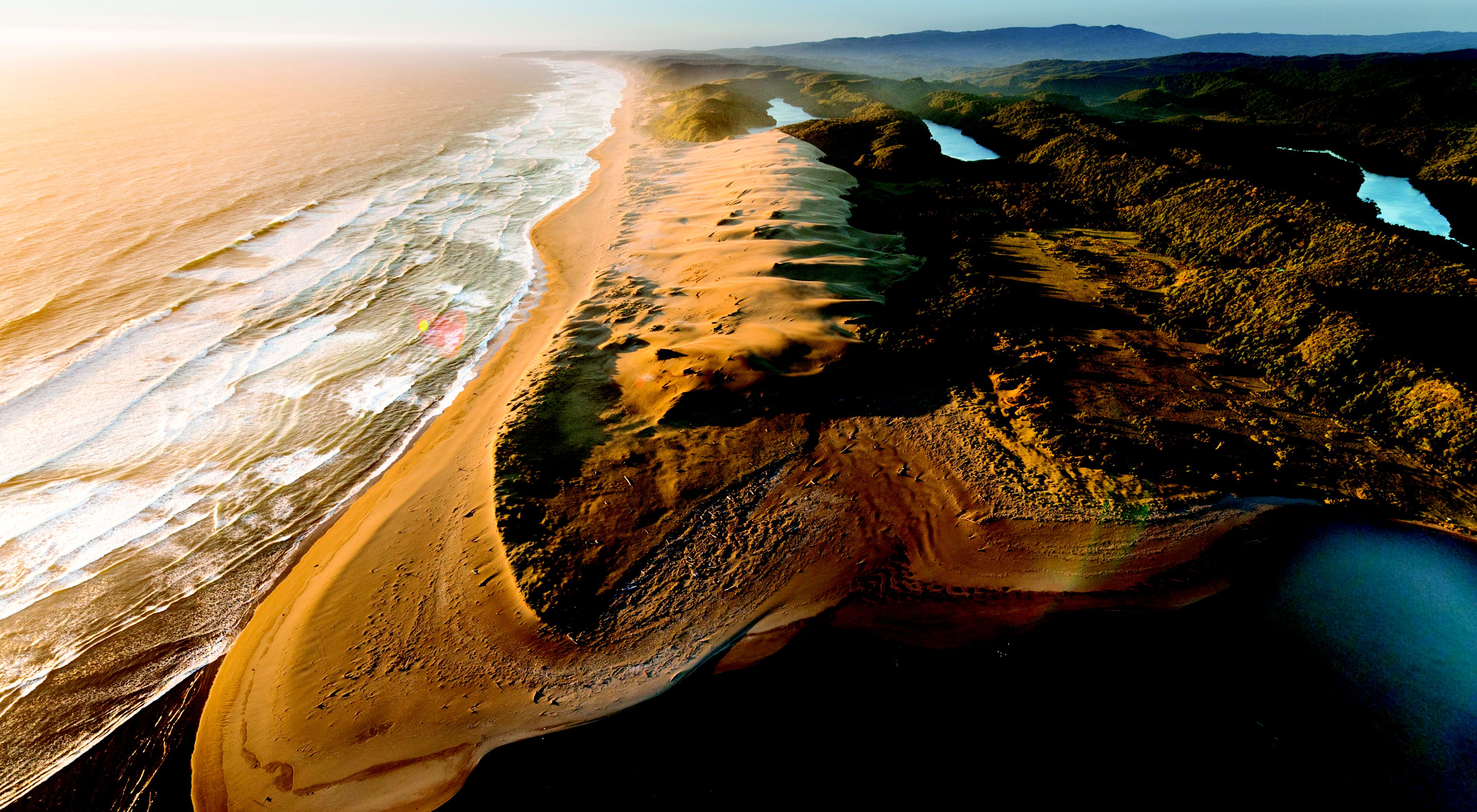 An aerial view of Colun Beach, sand dunes and the Colun River in the Valdivian Coastal Reserve, Los Rios, Chile. 