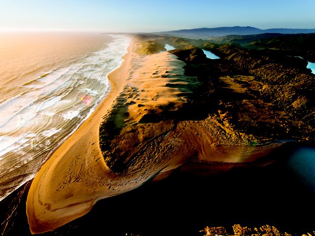 An aerial view of Colun Beach, sand dunes and the Colun River in the Valdivian Coastal Reserve, Los Rios, Chile. 
