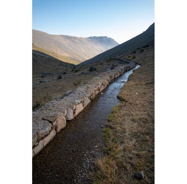 Agua corre por canal en las montañas.