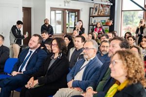 Un grupo diverso de personas sentadas en sillas, participando en una conversación durante una reunión.