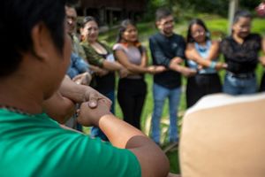 Un grupo diverso de personas de pie en círculo, tomadas de la mano, simbolizando la unidad y la unión.