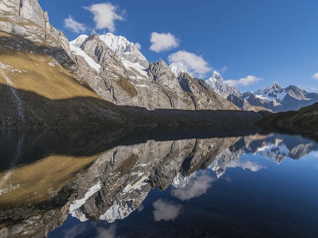 Montañas nevadas reflejadas en un lago alpino inmóvil