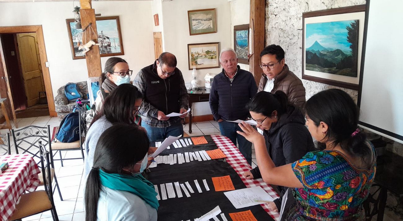 Participantes hablan en una reunión grupal.