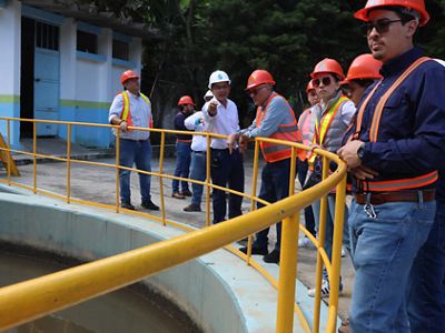 Un grupo de personas a la orilla de un pozo escuchan a un guía.