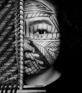 Self portrait, in black and white, of Joyce Anika with traditional painting in her face. 