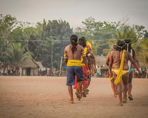 Indígenas andando em aldeia.