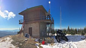 Hombre instala poste con ARU en una construcción rudimentaria entre las montañas.