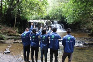 Cuatro personas vestidas con chaquetas azules se encuentran con los pulgares hacia arriba.