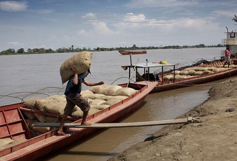 Un hombre descarga mercancías desde su bote en el río Magdalena en Colombia.