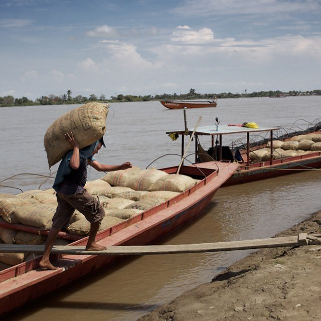 Un hombre descarga mercancías desde su bote en el río Magdalena en Colombia.