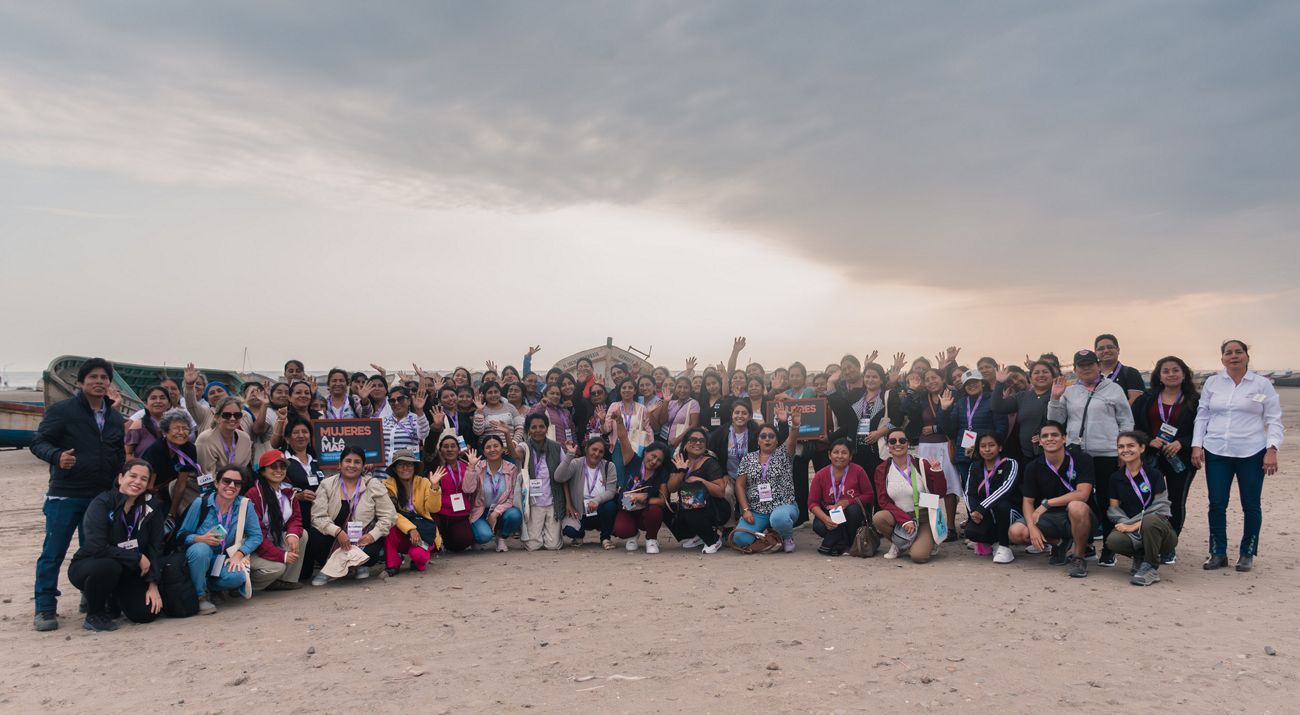 grupo de mas de 100 mujeres que participaron en evento de intercambio en la playa