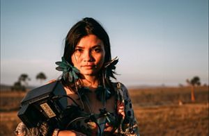 Portrait of Priscila Tapajowara, holding photographic equipment in the nature. 