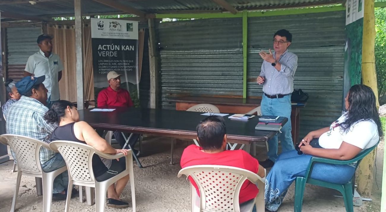 Una persona habla frente a un grupo de personas que le escucha.