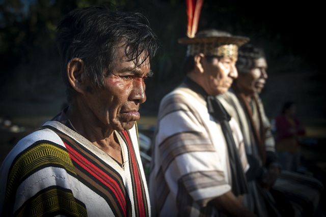 Três homens vestidos com trajes tradicionais permanecem juntos, exibindo vestimentas culturais e um espírito de companheirismo.