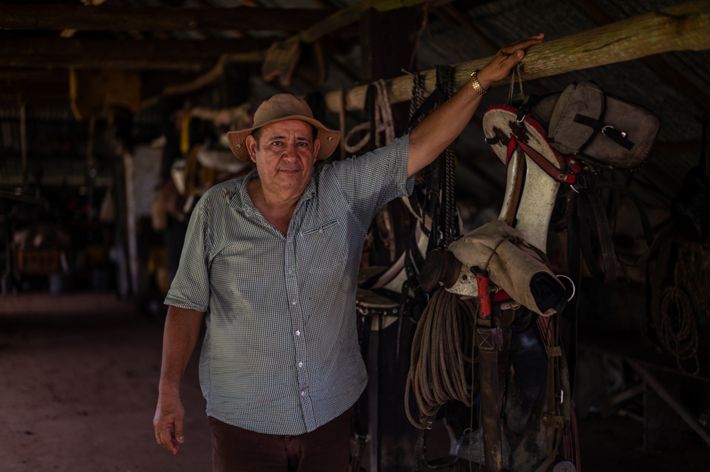 A man poses with a saddle.