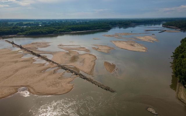 Aerial view of a rock jetty spanning the width of the muddy Mississippi River.