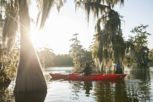 A person kayaks during a sunset.