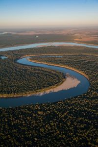  Aerial view of a river winding through forests.