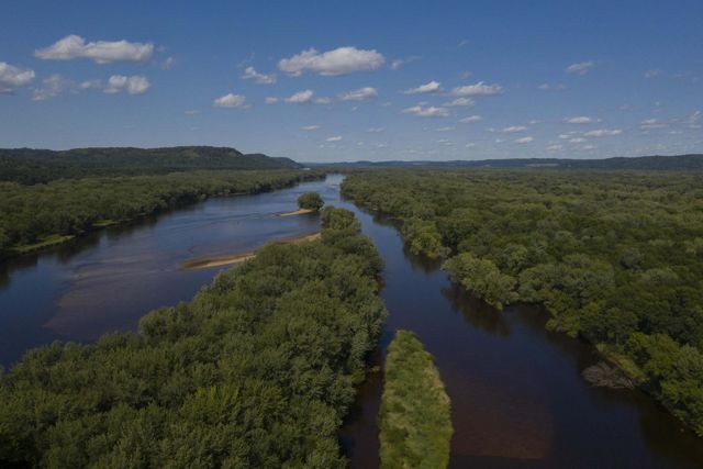 Aerial view of the Mississippi River flowing through heavily forested lands along its banks.