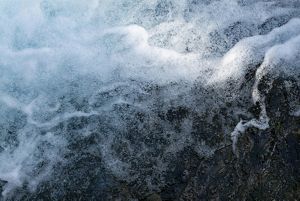 Fast moving water splashes in whitewater rapids.