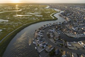 An aerial view of a coastal town surrounded by marsh and water.