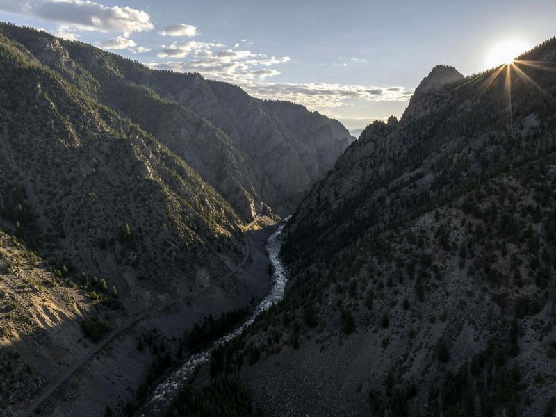 A setting sun casts a shadow over the Colorado River as it cuts through a canyon near Kremmling, Colorado.