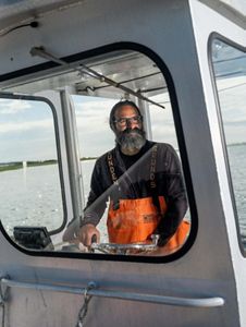 Carl Lobue stands at the wheel of his boat.