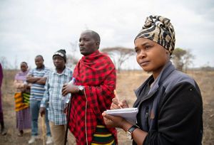 Warda Kanagwa stands with community members in Randilen Wildlife Management Area in Tanzania.