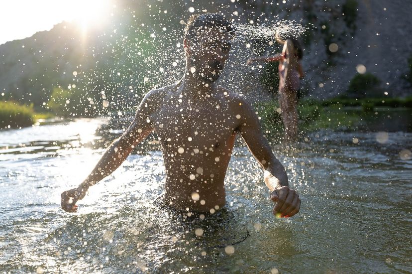 A person splashes water while swimming in the Krupa River.