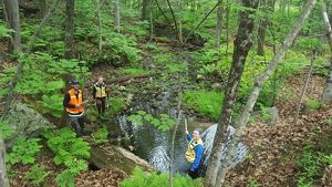 Hadley Couraud and peers out in the field taking measurements of culverts and stream data.