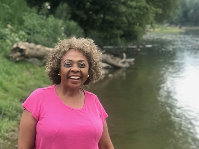Dr. Mamie Parker laughs while standing near a lake by her home in Virginia.