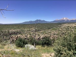 A wide valley stretches to the horizon where it means a towering mountain peak.