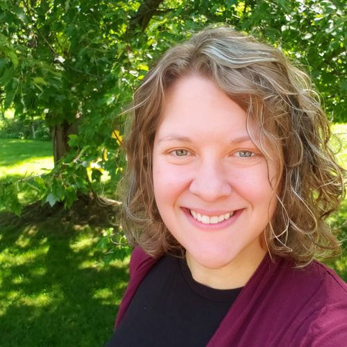 Adrienne Marino smiling in front of a tree.