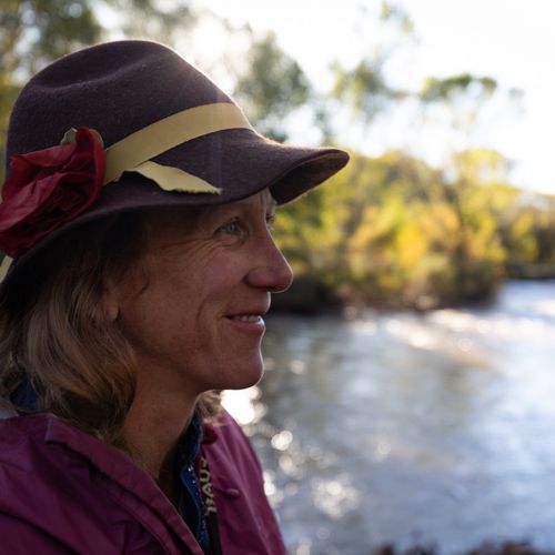 Side profile of Martha Cooper smiling and wearing a hat.