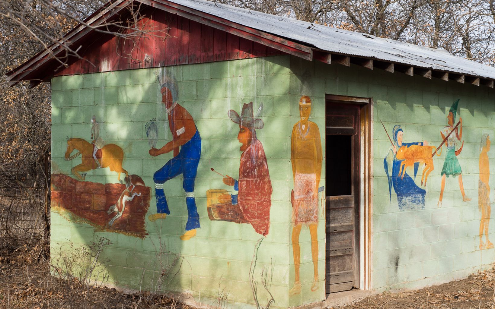 Mathews painted his depiction of the history of man on his outbuilding near the cabin.