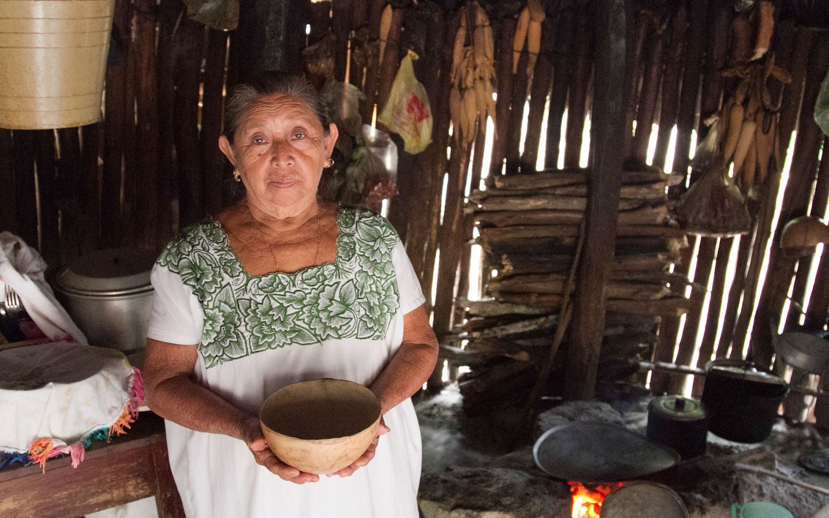 a maya's womens holds a container that is used to hold water