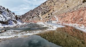 A river rushes through a landscape flanked by tall rock walls.