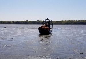 An airboat travels across a body of water.