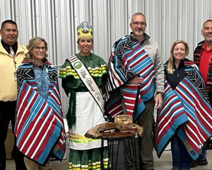 Three men and three women stand together following an exchange of ceremonial gifts.