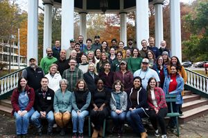 Group of people posing for a photo with a monument in the background.