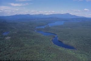An aerial view of Mount Katahdin and surrounding forests and rivers.