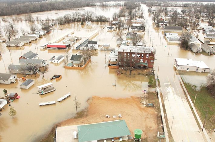 A small town's buildings and roads underwater from a flood.