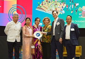 A group of people holding an award smiling for a photo.