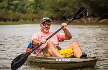 Man kayaking on Kiamichi River in Oklahoma.