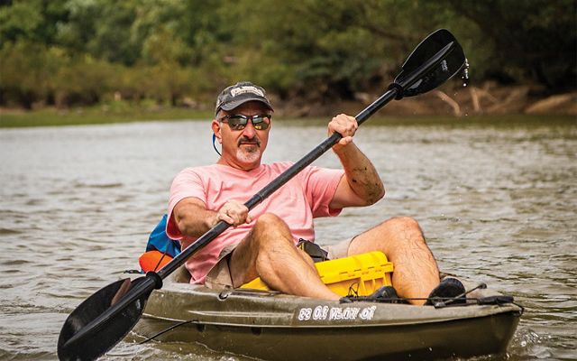 Man kayaking on Kiamichi River in Oklahoma.
