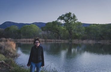 Person laughing standing outside.