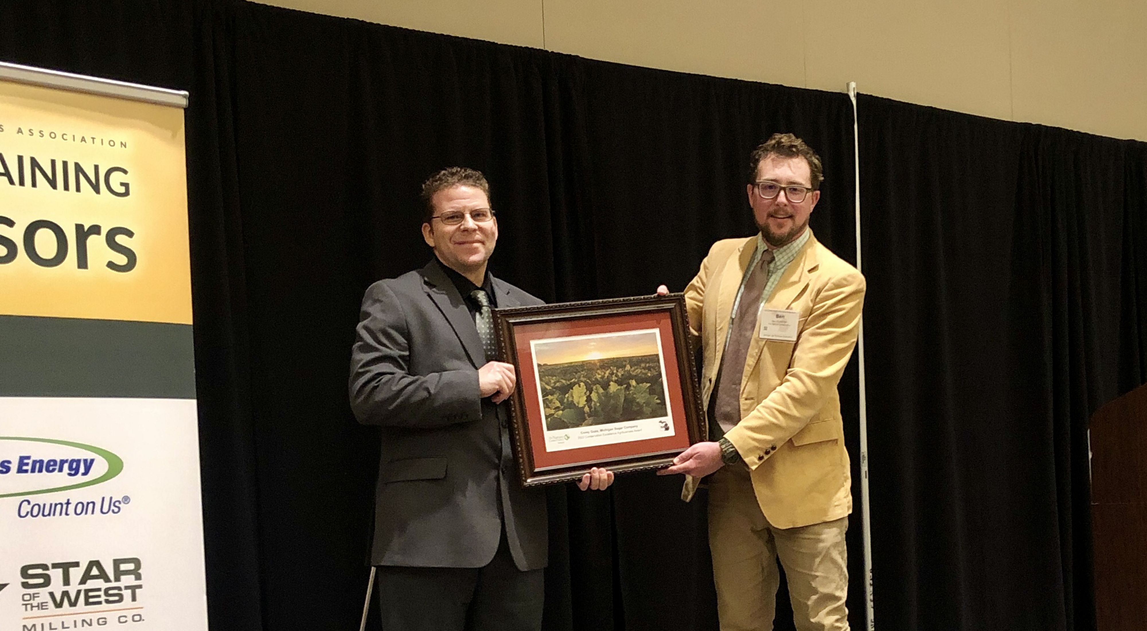 Corey Guza (left) and Ben Wickerham (right) hold the framed agribusiness award.