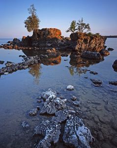 A rock formation on a calm shore.