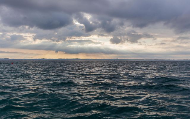The choppy surface of Lake Michigan on a cloudy day. The sun is shining through the clouds and reflecting in the water’s surface.
