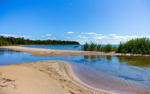View from the shore of the North Point property. The water of Lake Huron is bright blue as is the sky.  